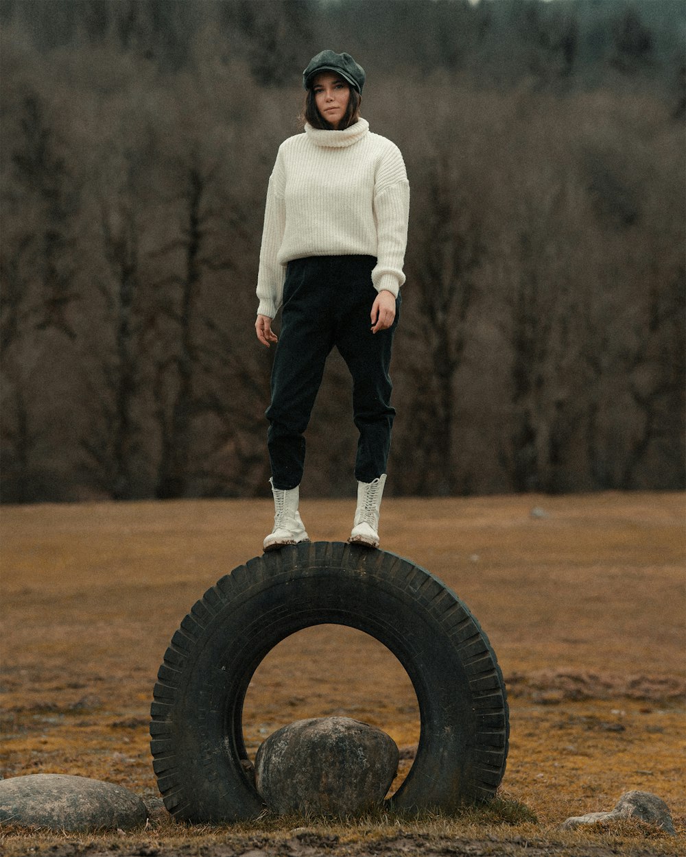 man in white sweater and black pants standing on black wheel