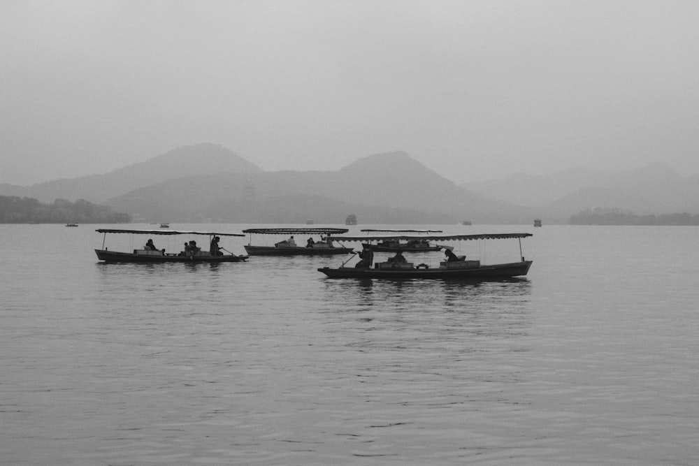 Foto en escala de grises de personas montando en barco en el mar