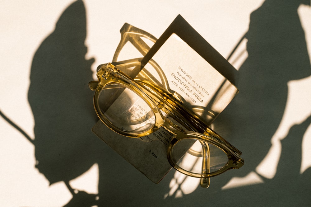 gold framed eyeglasses on white paper