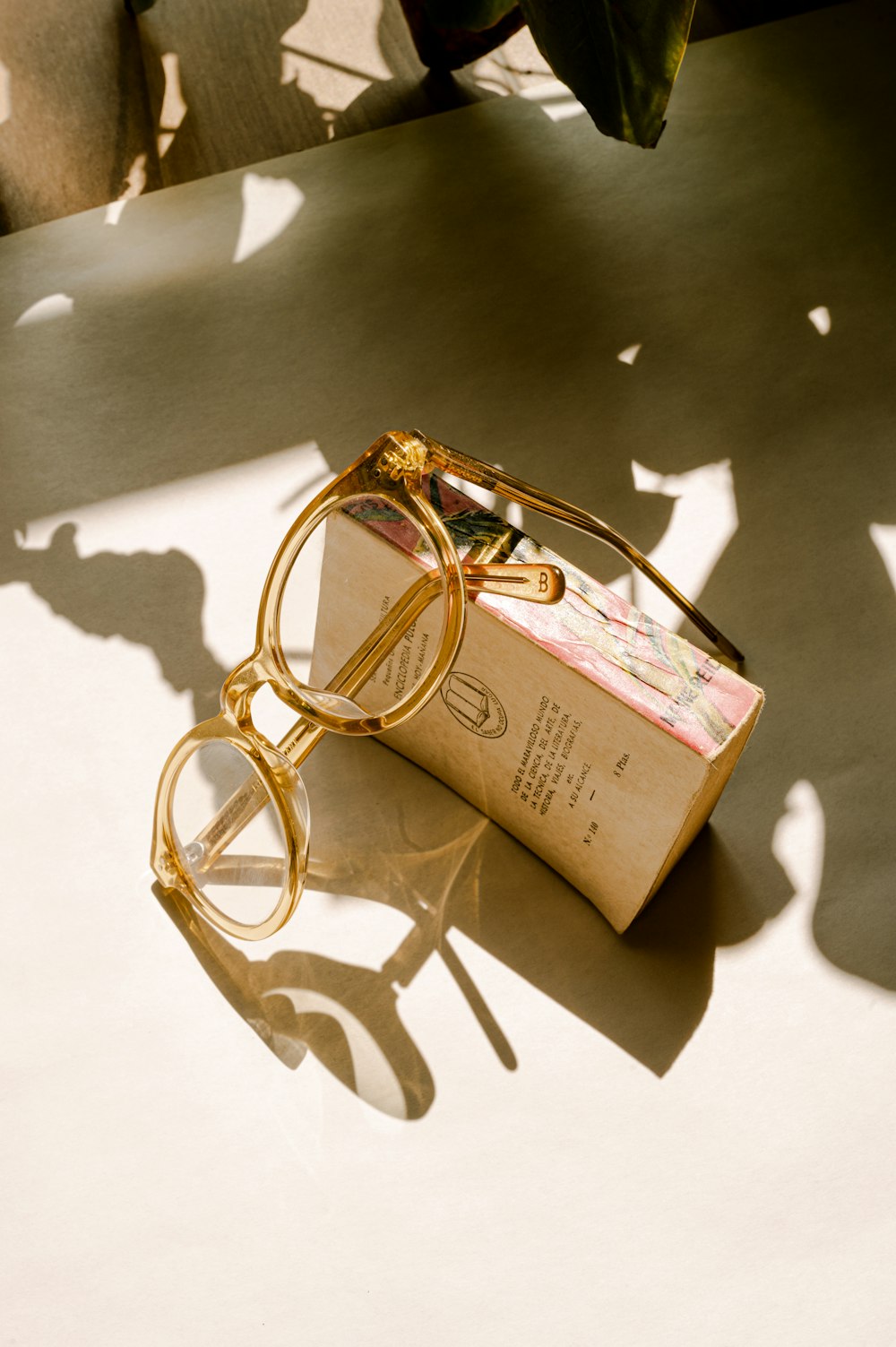 gold framed eyeglasses on brown box