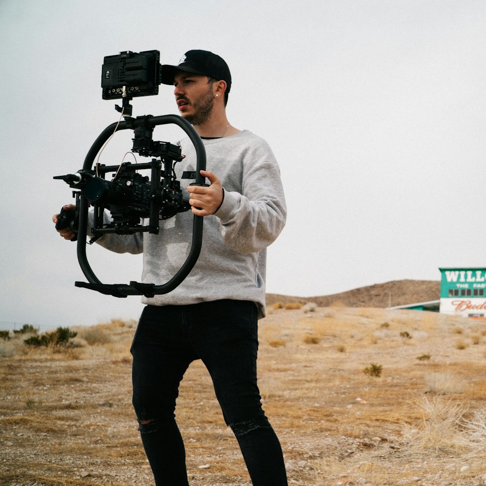 man in white long sleeve shirt holding black dslr camera