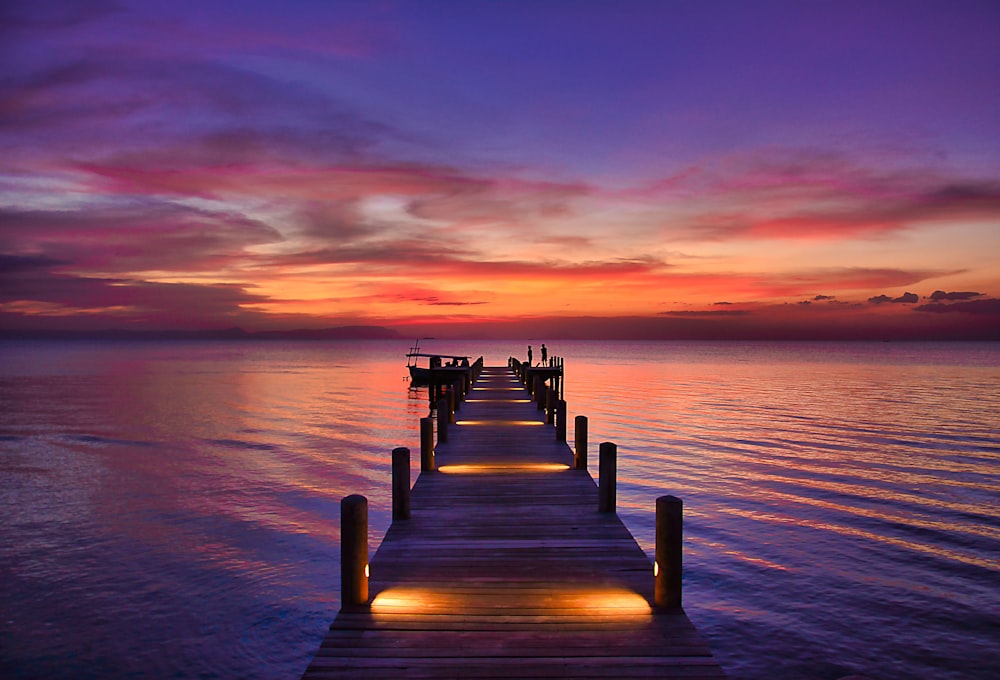 Braunes Holzdock auf See bei Sonnenuntergang