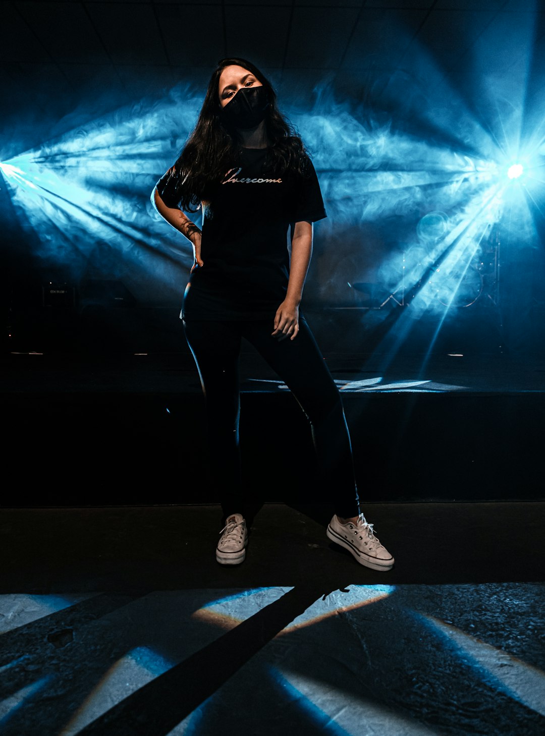 woman in black shirt and black pants standing on gray concrete floor