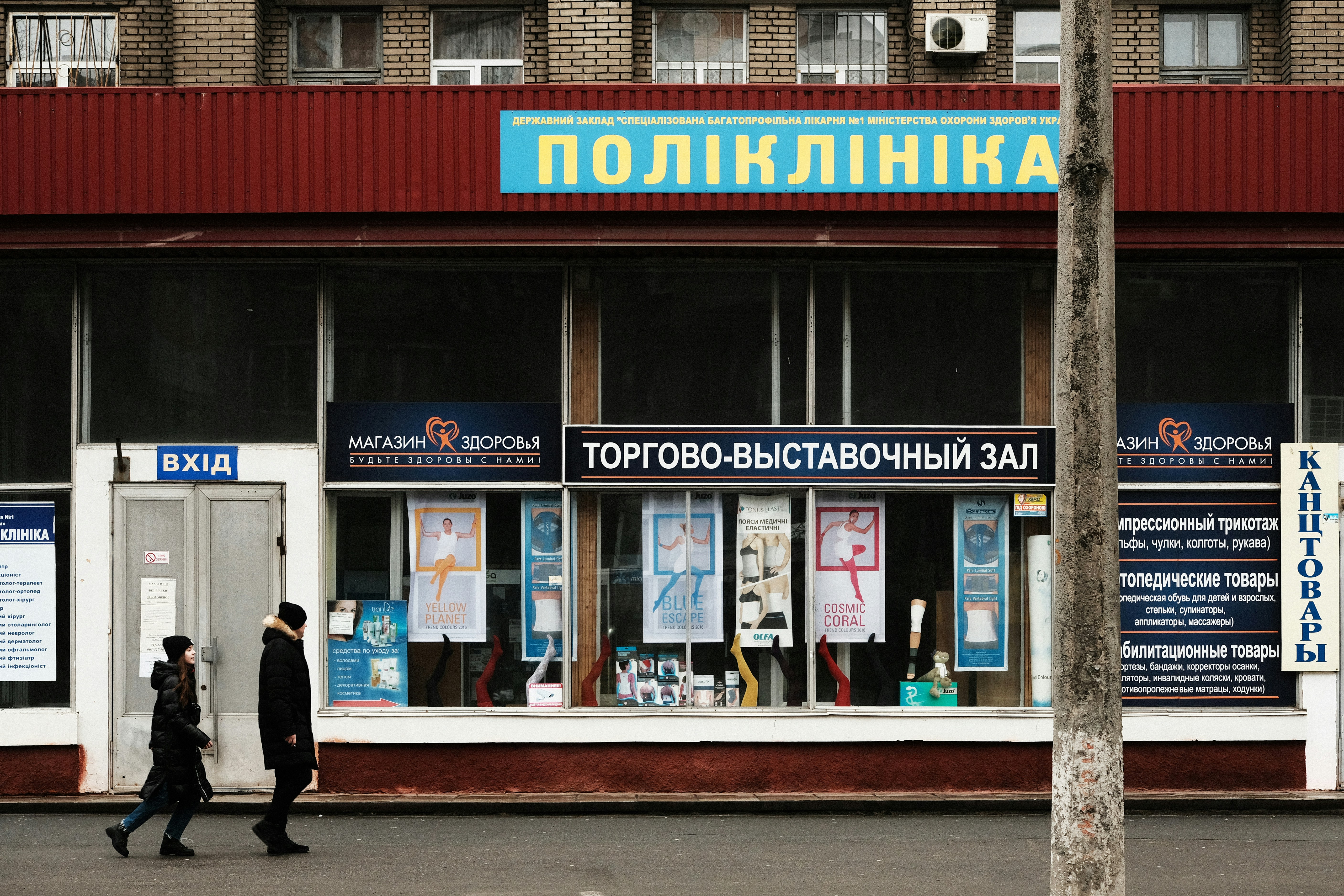 man in black jacket walking on sidewalk during daytime