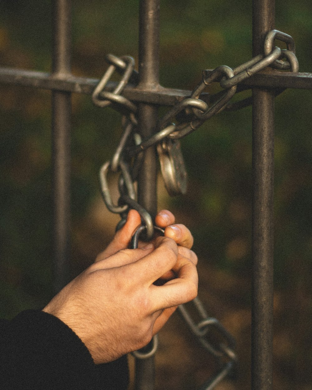 person holding gray metal chain