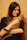 Smiling woman holding a small cat inside a warm, inviting pet shop.