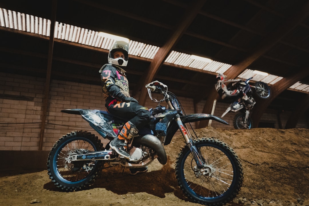 man in black helmet riding blue and white motocross dirt bike