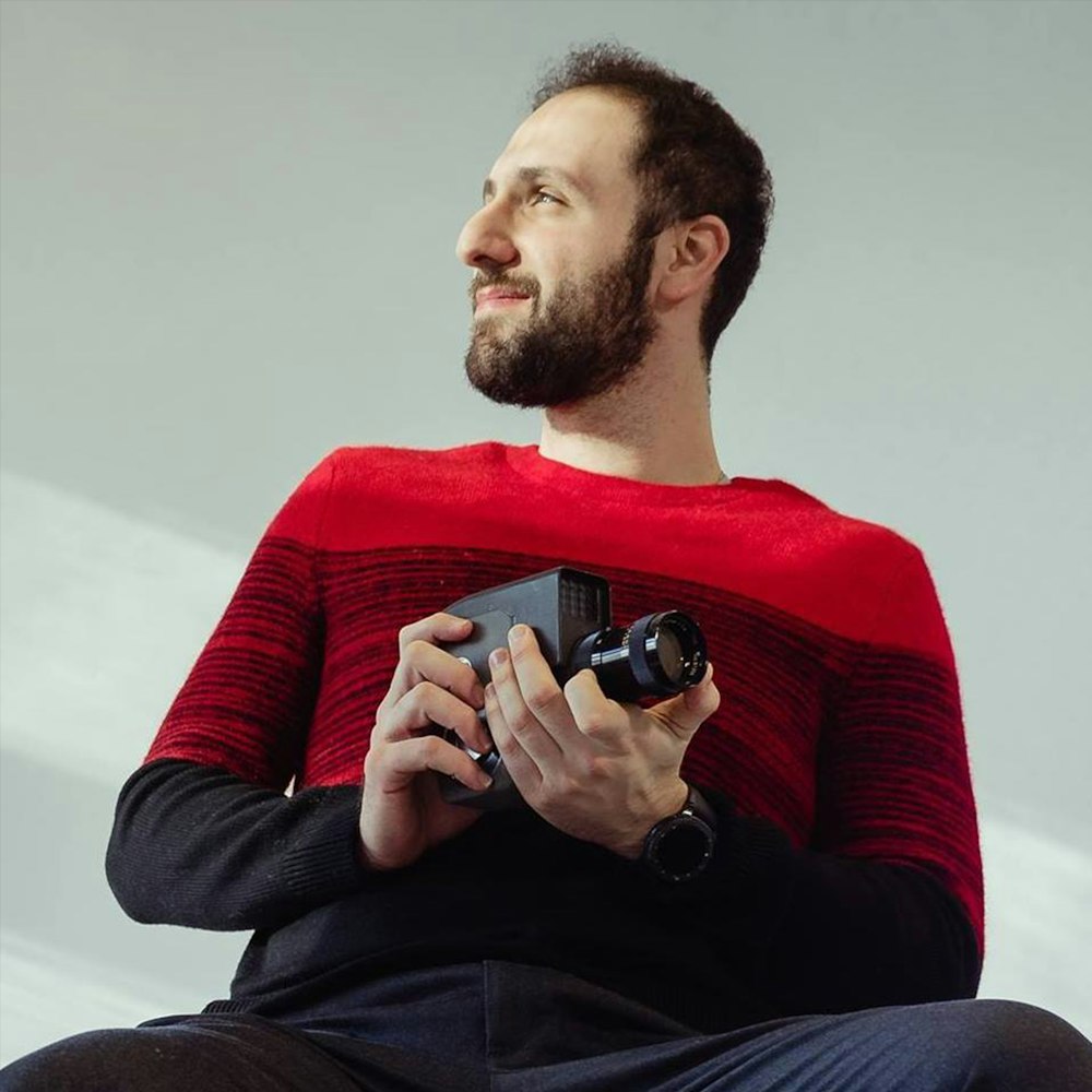 man in black long sleeve shirt holding black and silver camera