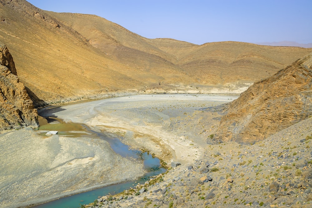 Brauner Berg neben blauem Meer unter blauem Himmel tagsüber