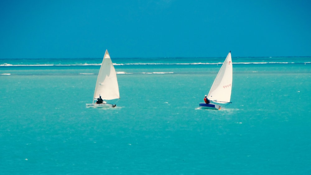 white sailboat on sea under blue sky during daytime