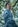 man in blue jacket standing near green trees during daytime