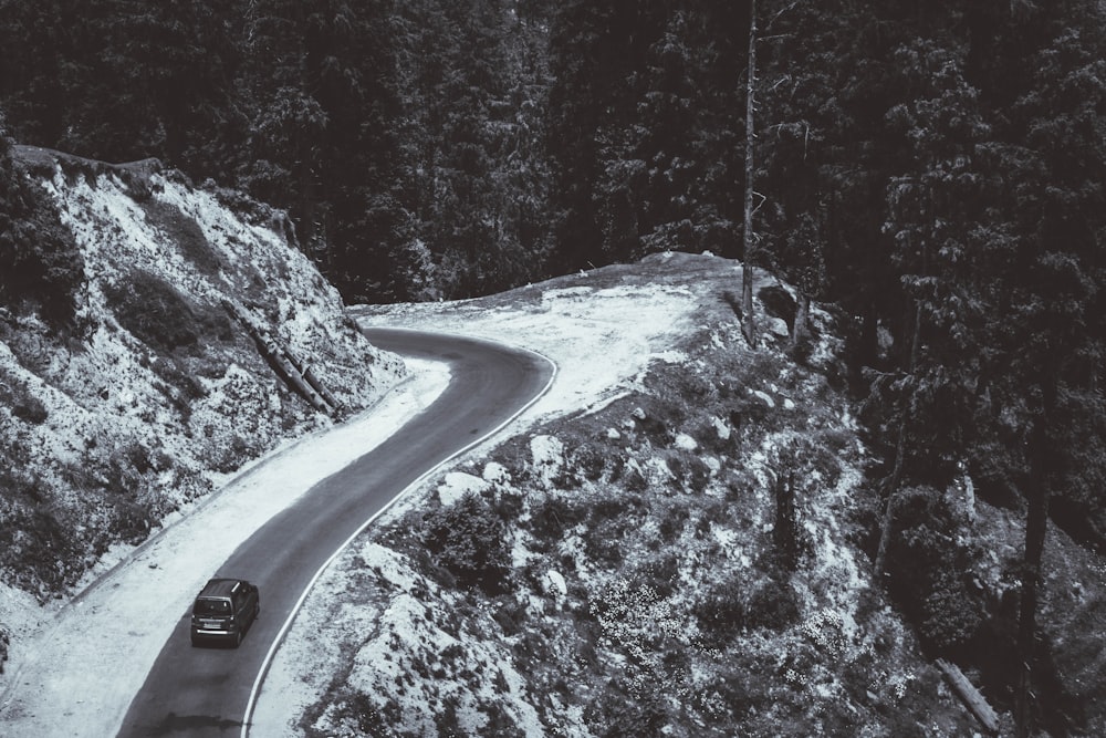 Coche negro en la carretera entre árboles cubiertos de nieve durante el día