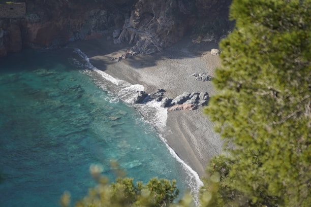 Secluded pristine beach with crystal-clear water and natural rock formations.