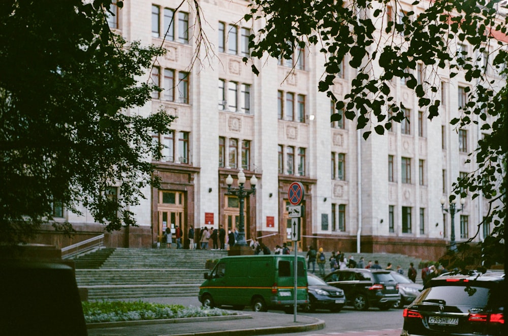 cars parked in front of white concrete building during daytime