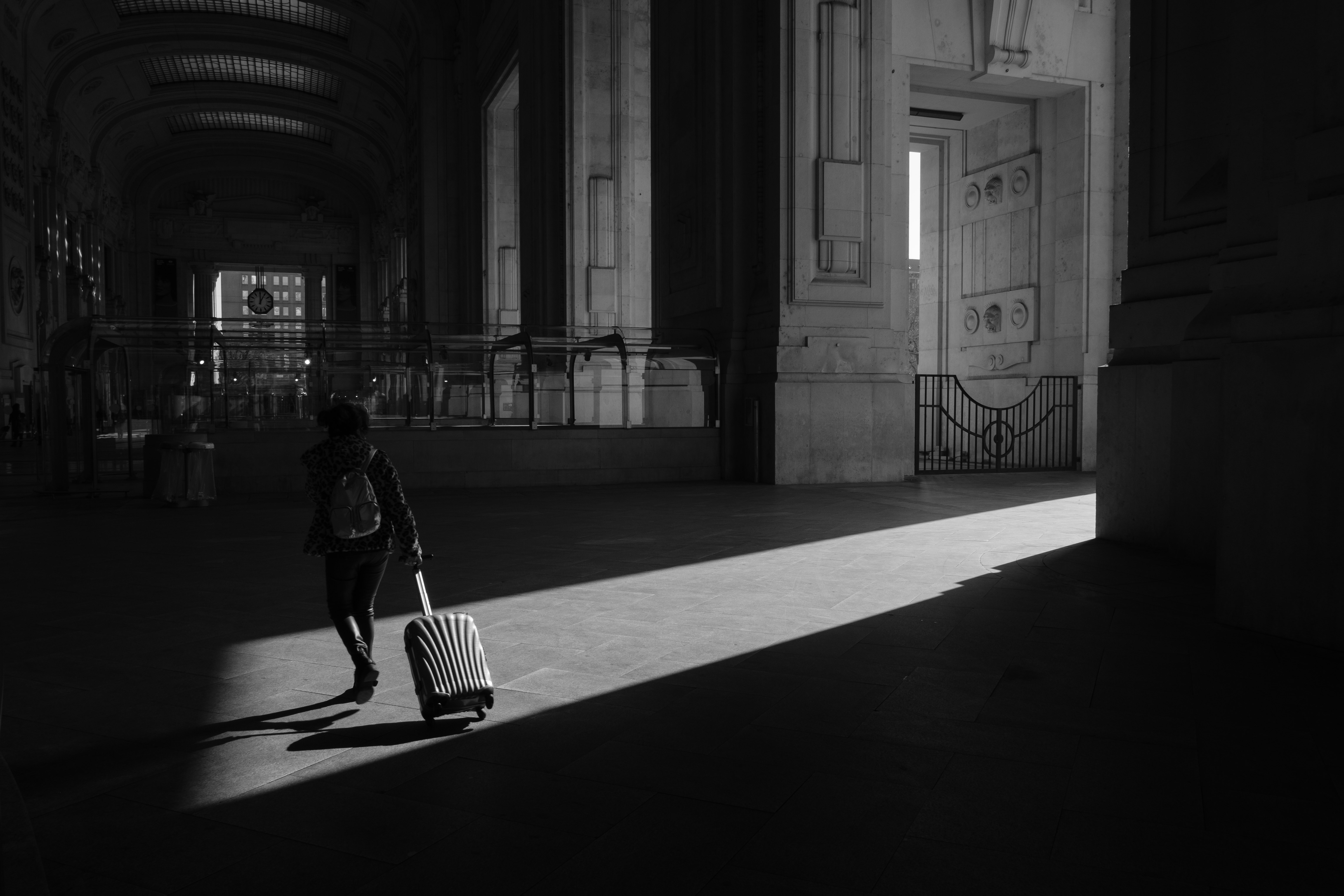 grayscale photo of woman walking on hallway
