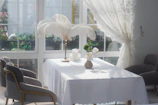 Natural light flooding a room with a table set in crisp white linen tablecloth and napkins.