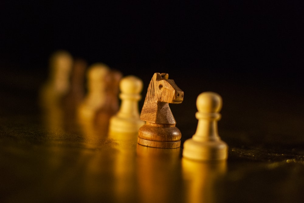 brown wooden chess piece on brown wooden chess piece