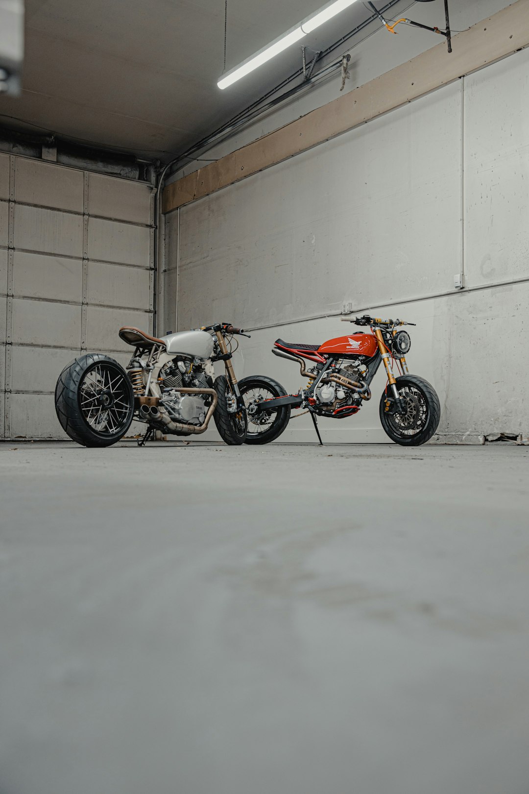 red and black motorcycle parked beside white wall