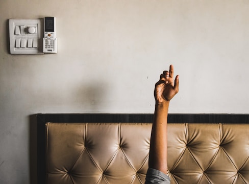 Close-up of hands adjusting remote control for electric bed