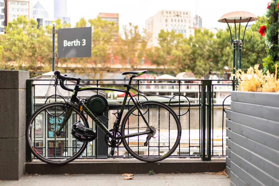 black city bike parked beside black metal fence during daytime