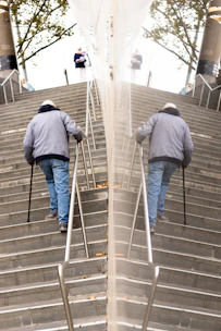 An elderly person using an easystep assisted device to climb stairs comfortably.