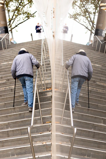 An elderly woman confidently using the Easystep device to climb a short flight of stairs in her cozy home.