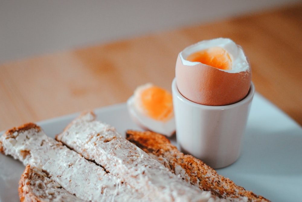 Pan con huevo en plato de cerámica blanca