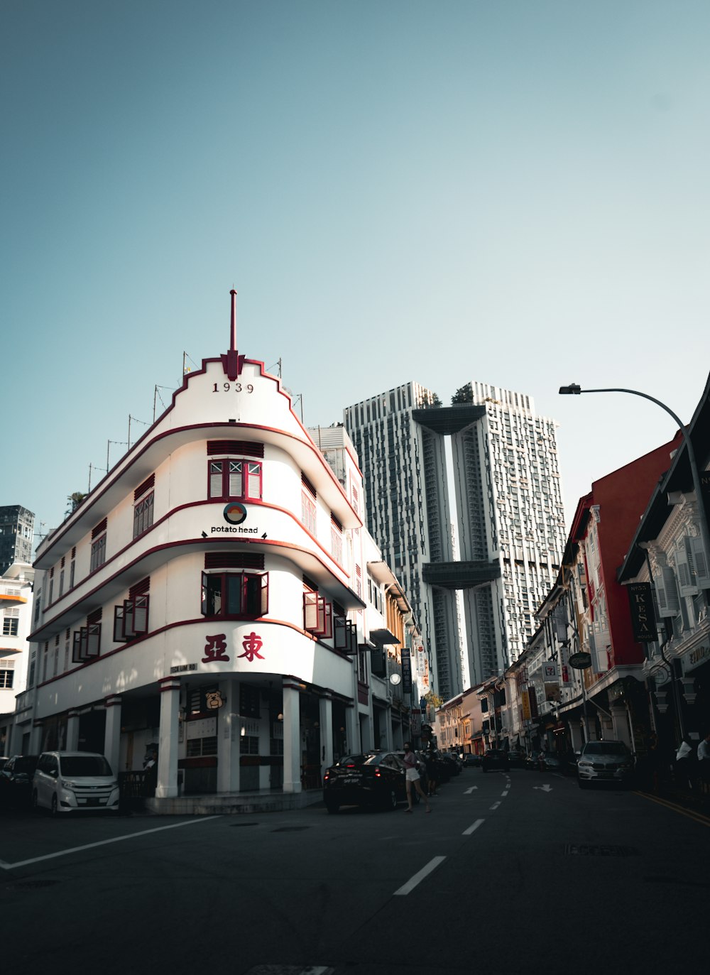 cars parked beside red and white concrete building during daytime