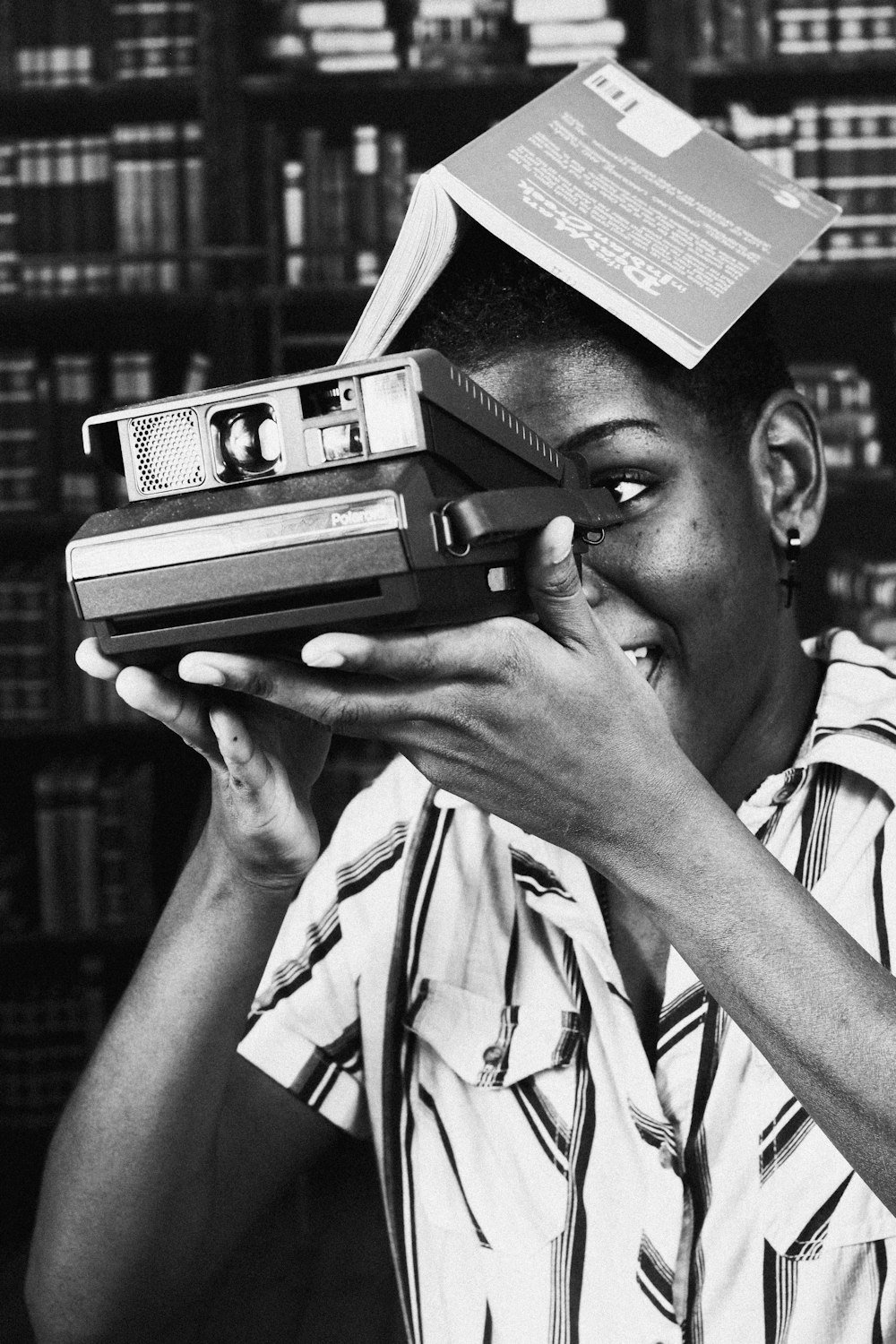 man holding polaroid camera grayscale photo