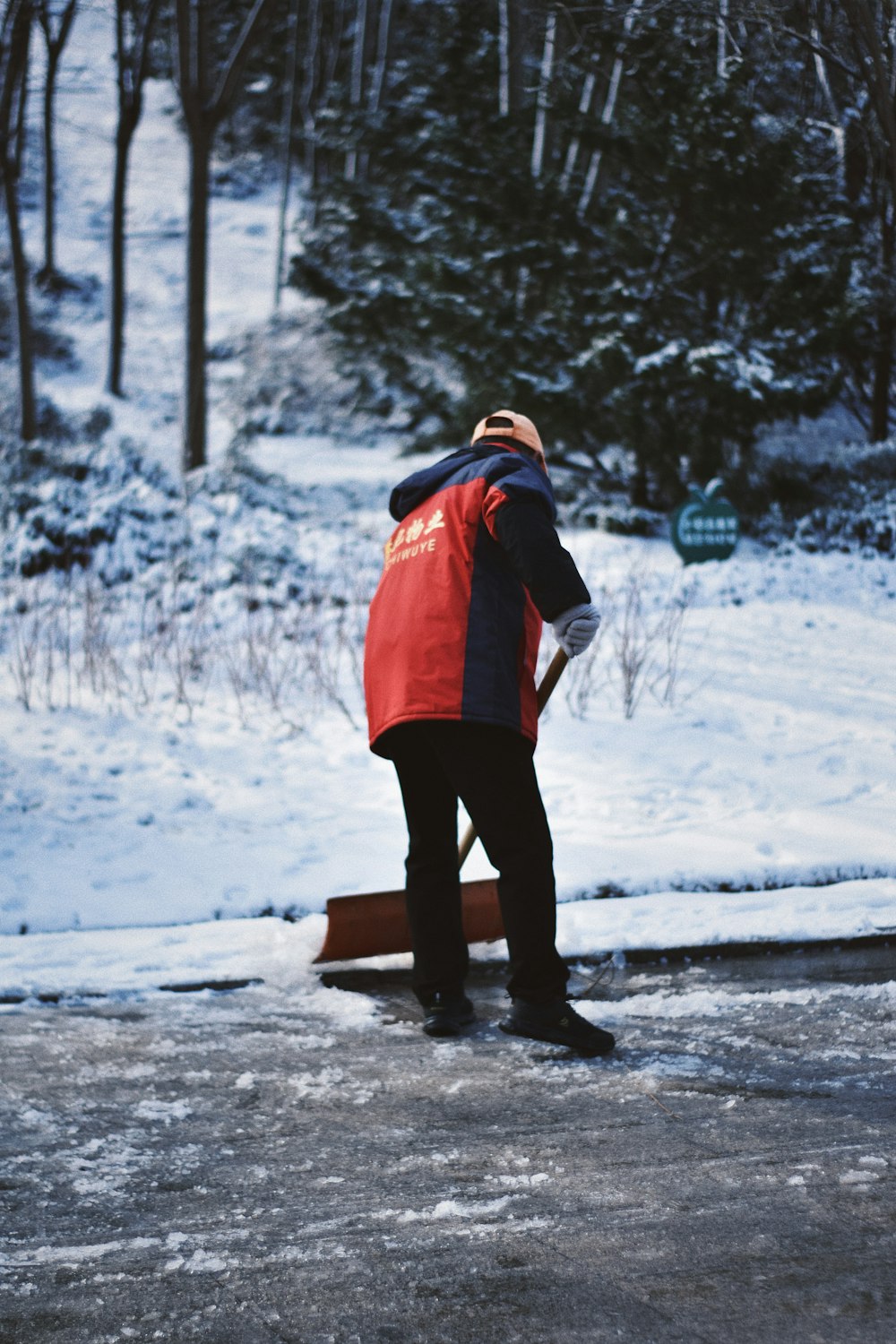 person in red and black jacket standing on snow covered ground during daytime