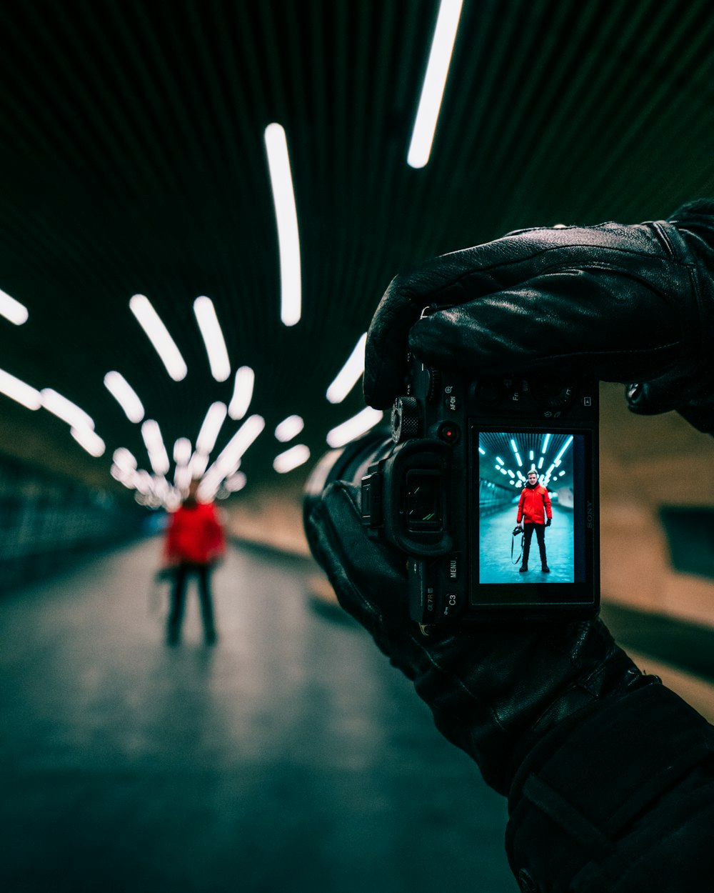 person in black leather jacket taking photo of white and red heart shaped light