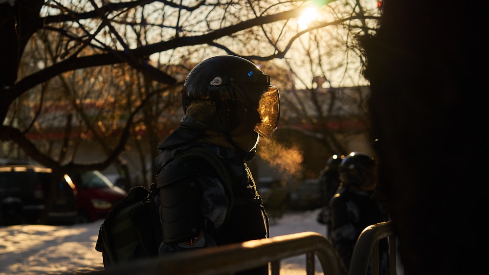 Homme en veste noire et casque noir assis sur un banc pendant la journée