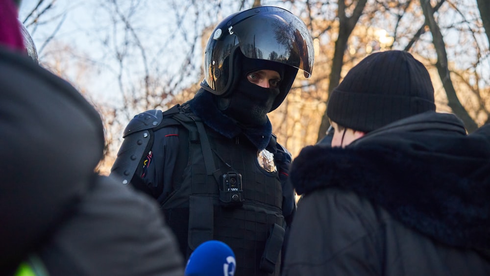 homme en veste noire portant un casque