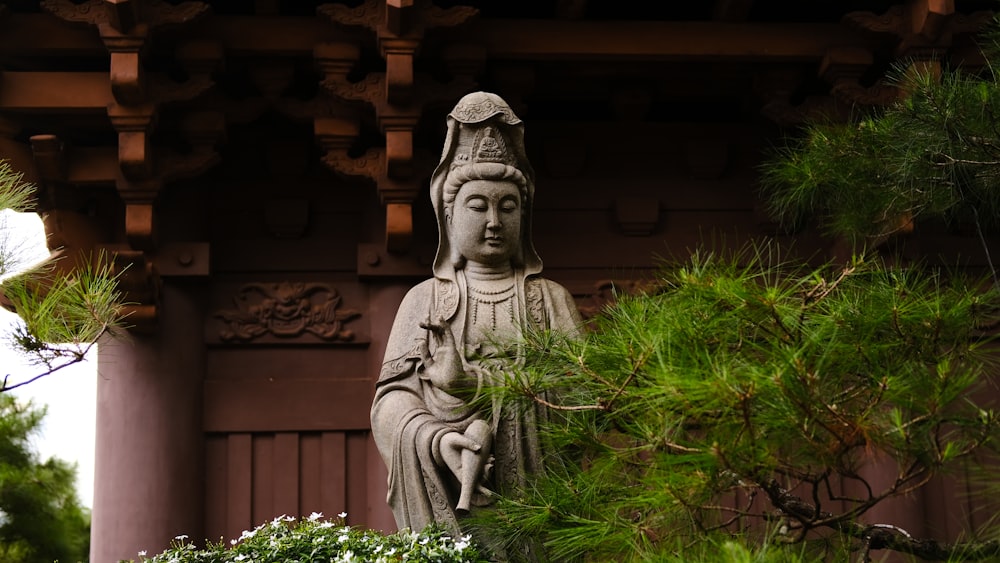 gray concrete statue near green plants