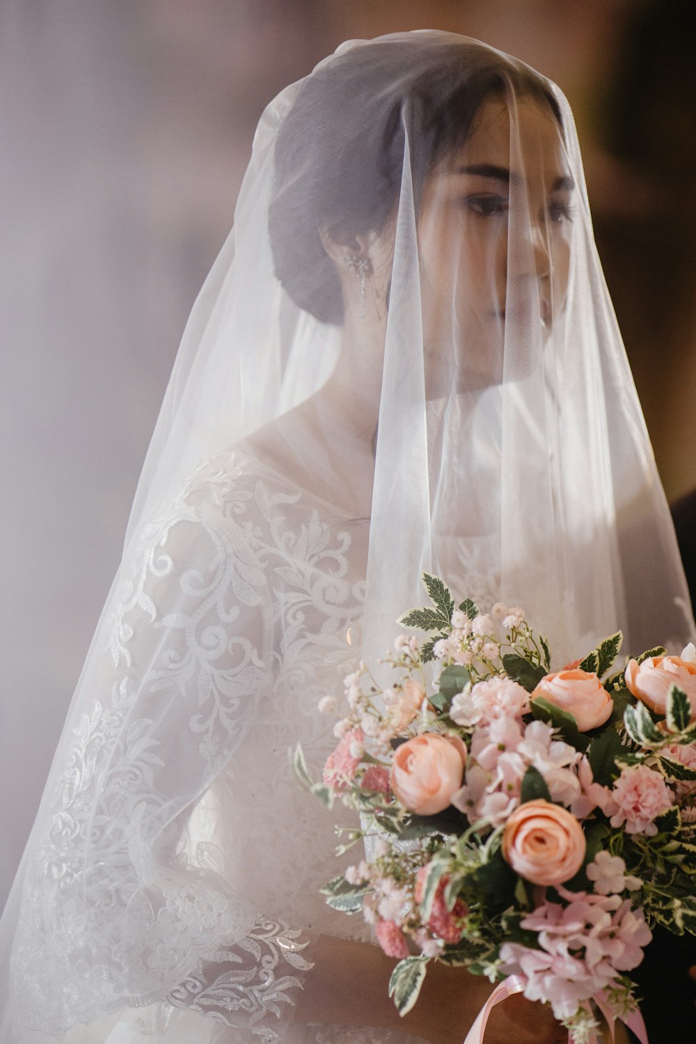 mulher no vestido de noiva branco que segura o buquê das flores