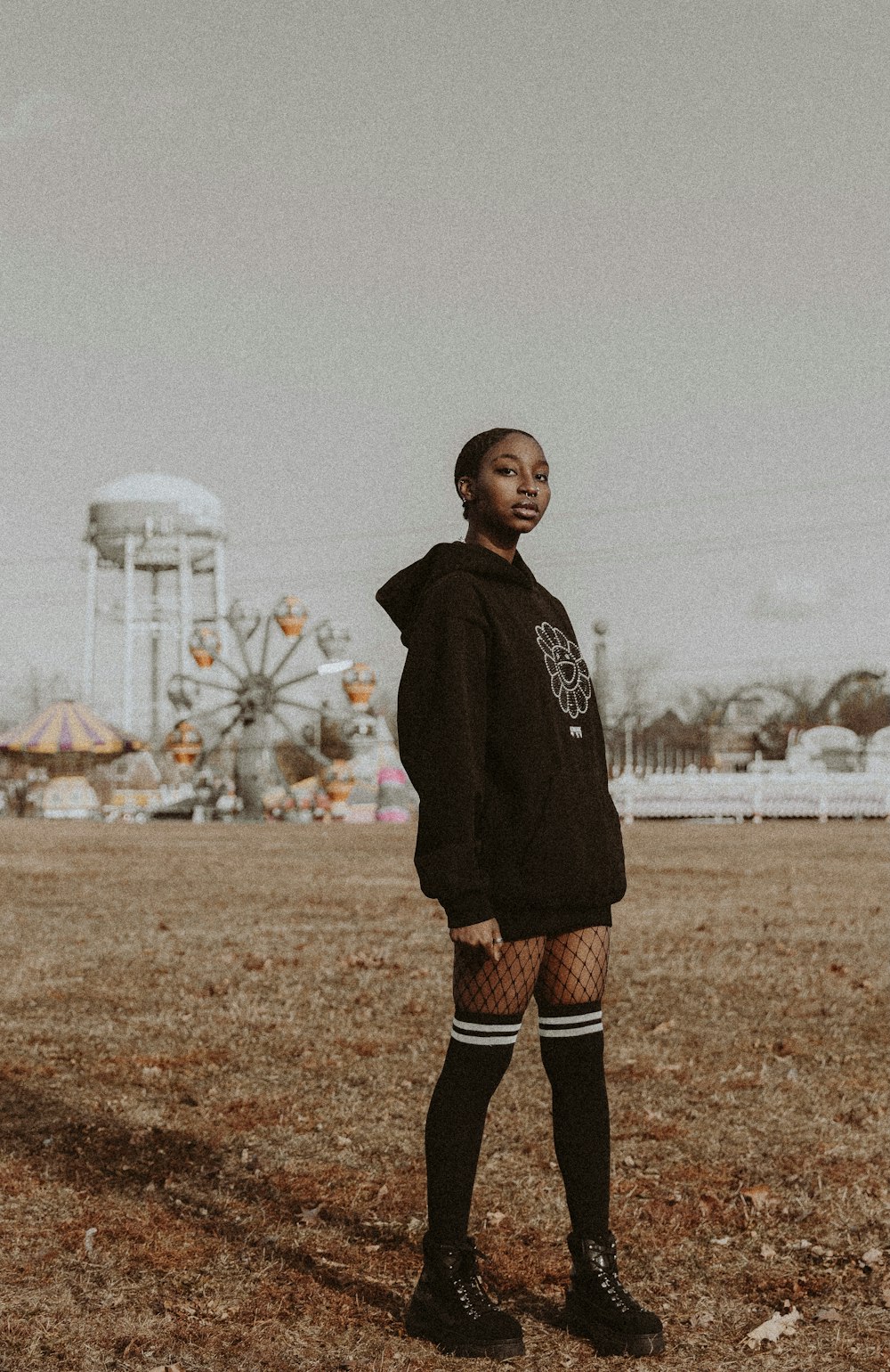 boy in black hoodie standing on brown field during daytime