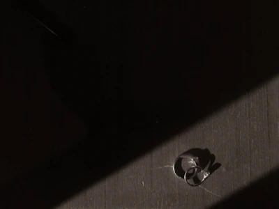 Minimalist ring displayed on a dark textured surface with subtle lighting.