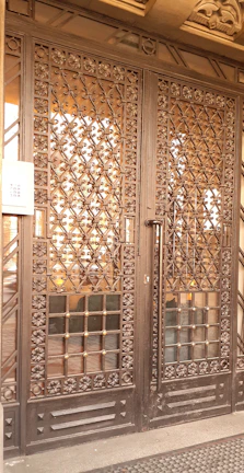 Close-up of a sleek black and silver aluminum gate with intricate wrought iron details.
