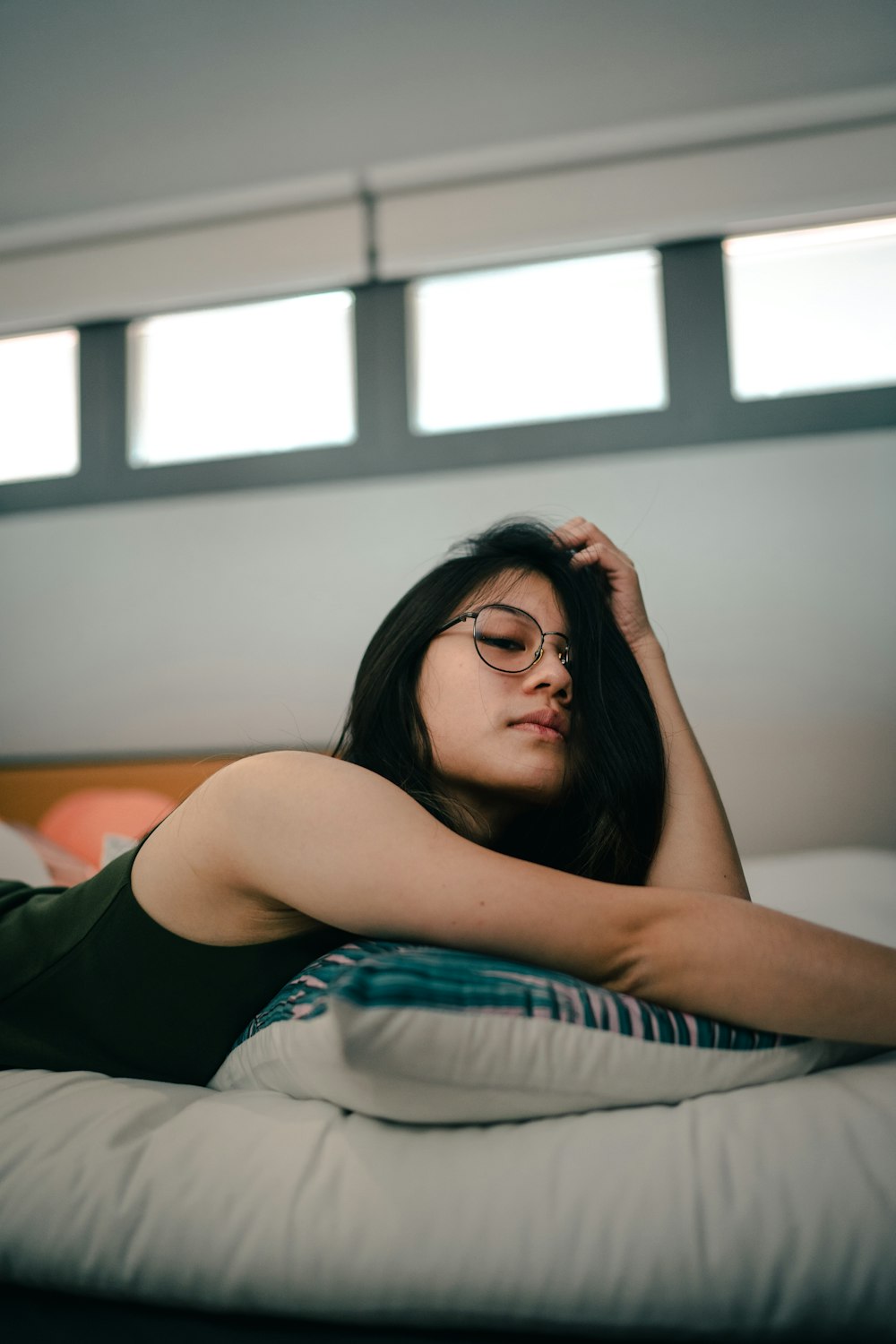 woman in black tank top lying on bed