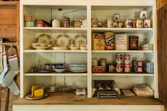 assorted ceramic mugs on white wooden shelf