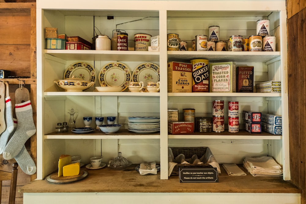 assorted ceramic mugs on white wooden shelf