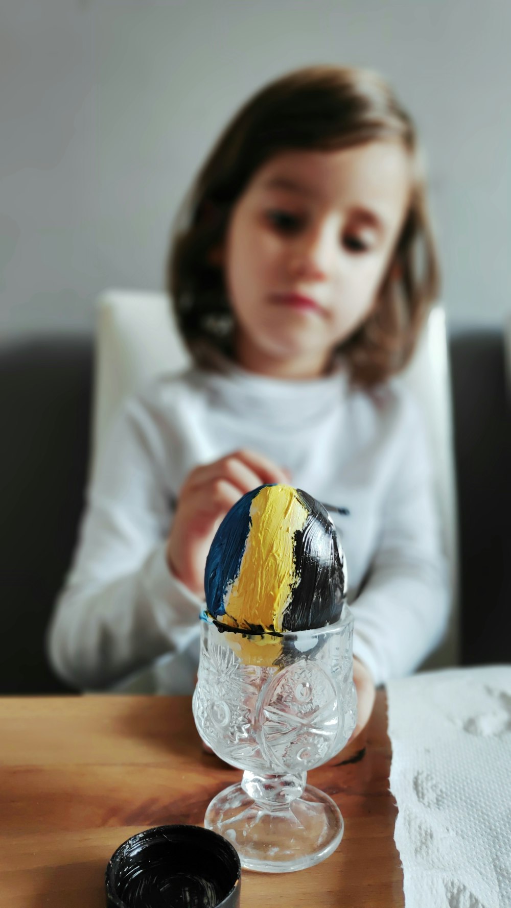 girl in white long sleeve shirt holding yellow and blue ball