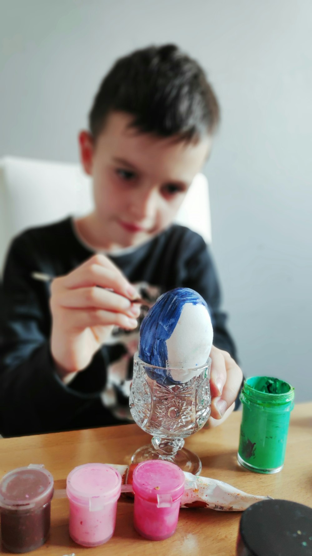 boy in black long sleeve shirt holding clear glass jar