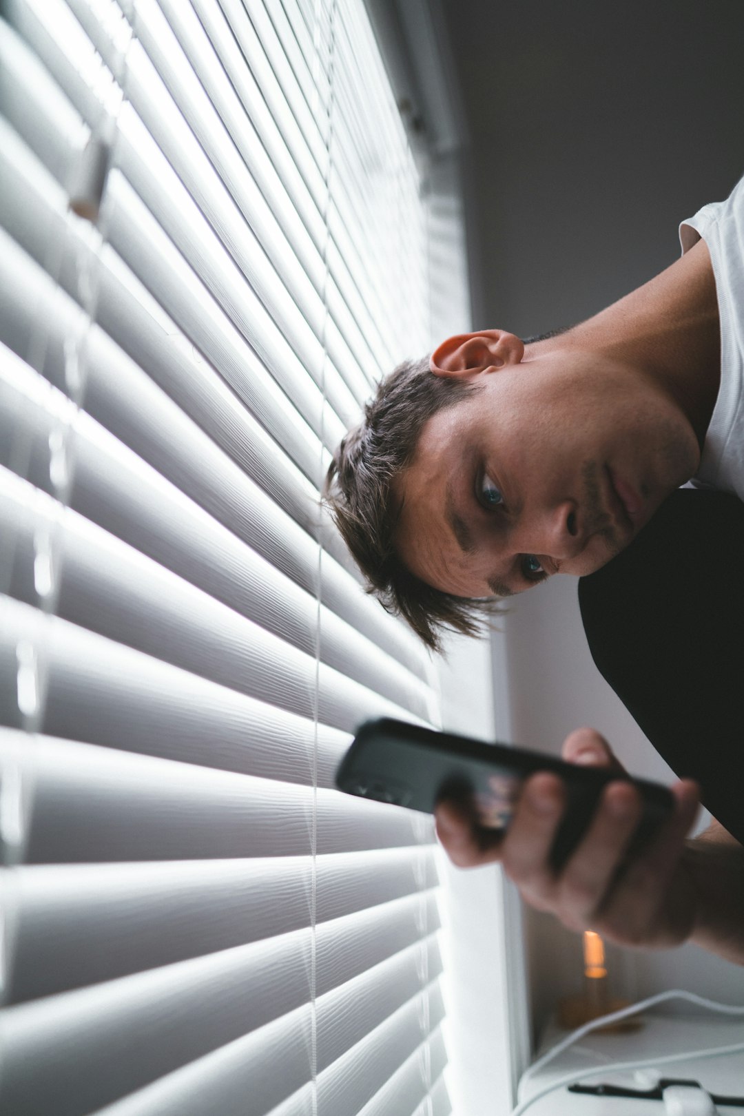 man in black crew neck shirt holding black remote control