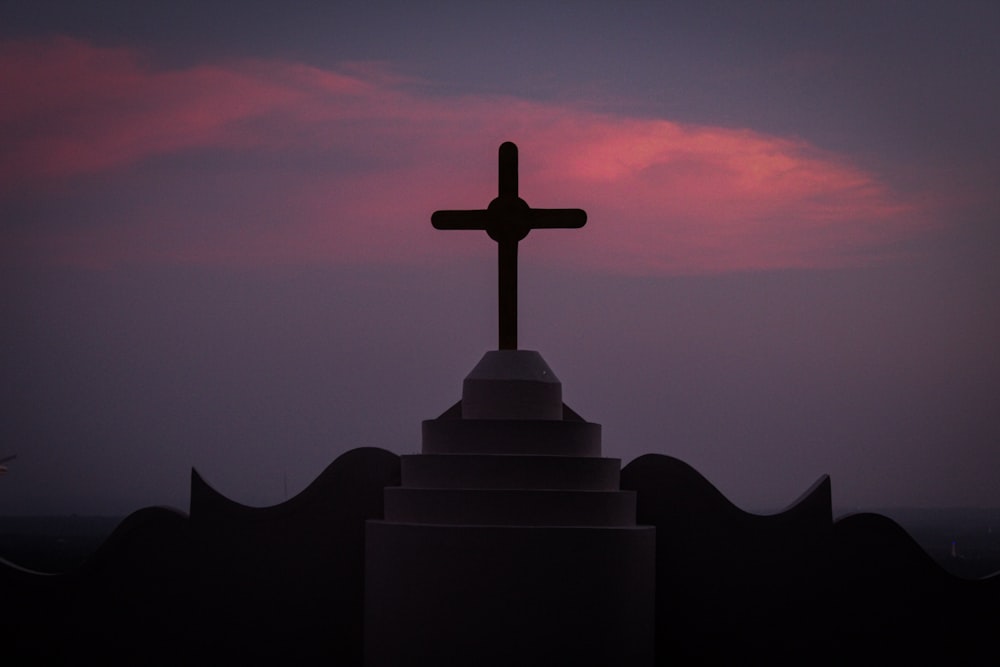 silhouette of cross on roof during sunset