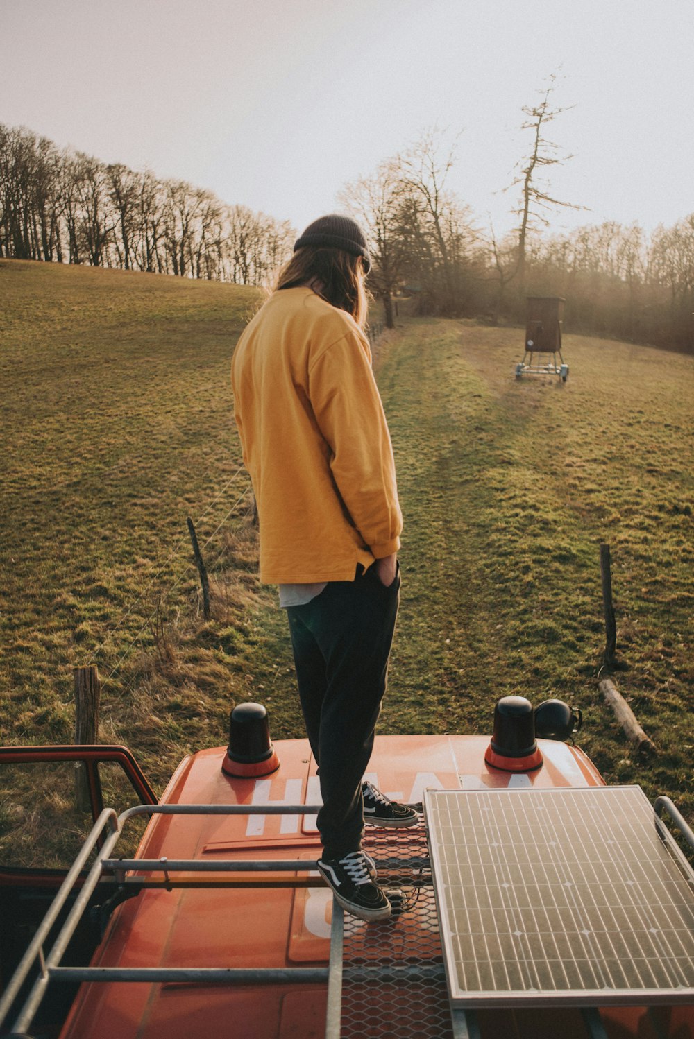 man in brown hoodie standing near brown wooden table