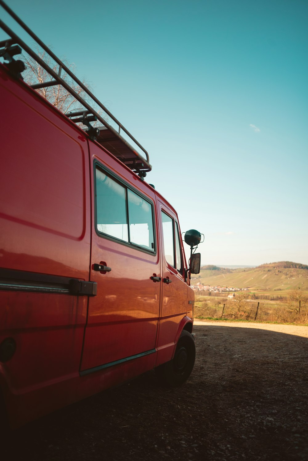 red van on brown dirt road during daytime