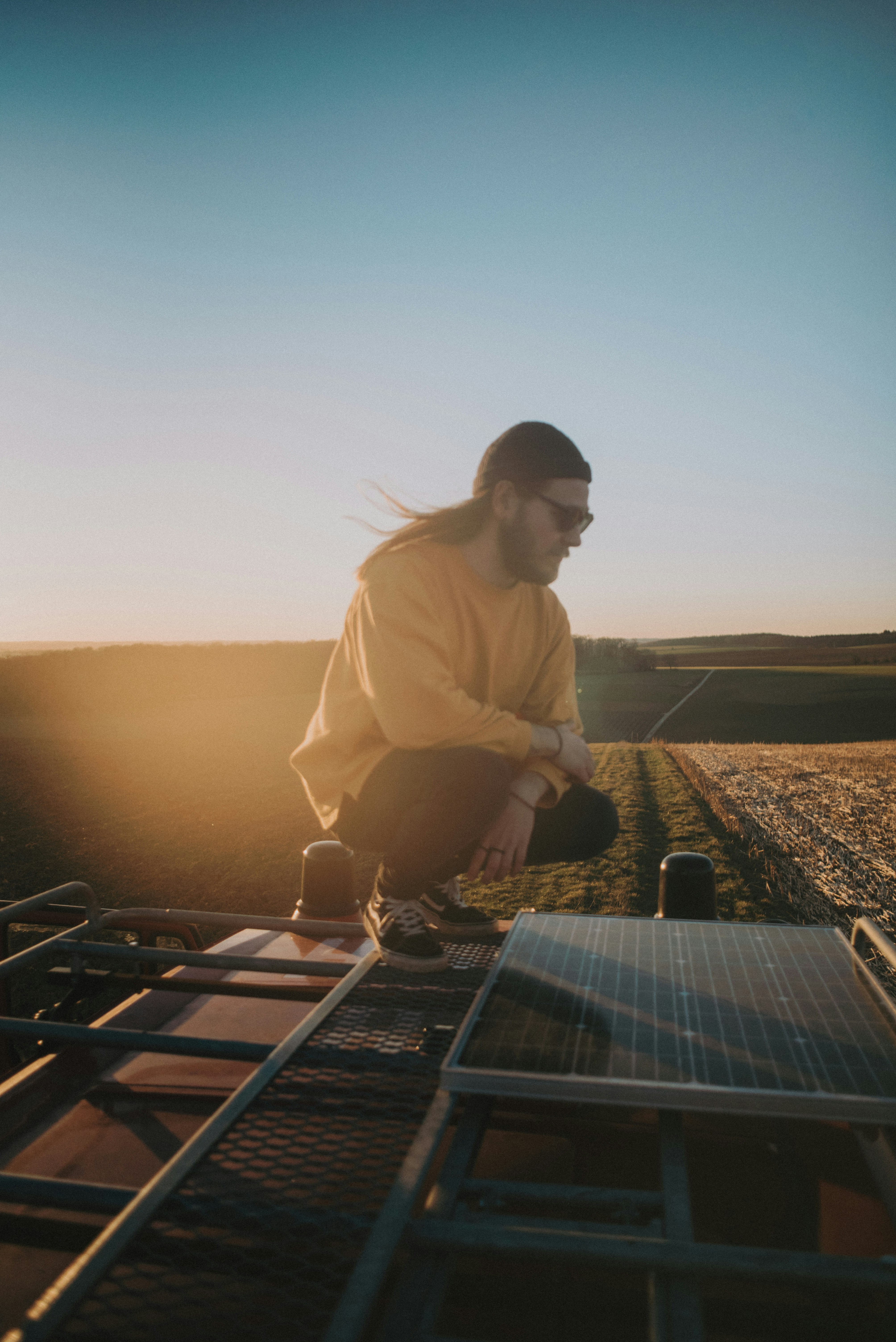 man in white dress shirt and black sunglasses standing on top of the building during daytime
