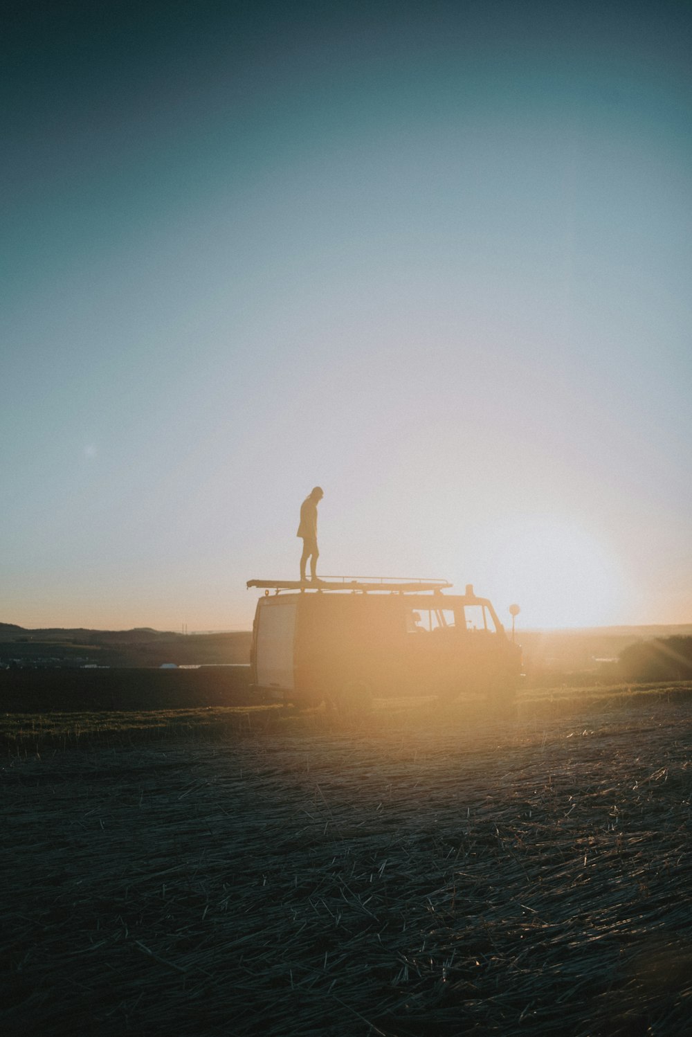 silhouette of person standing on white boat during sunset