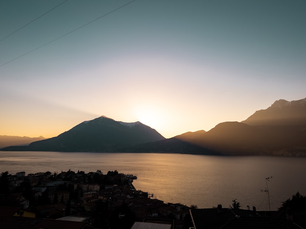 silhouette of mountain near body of water during daytime